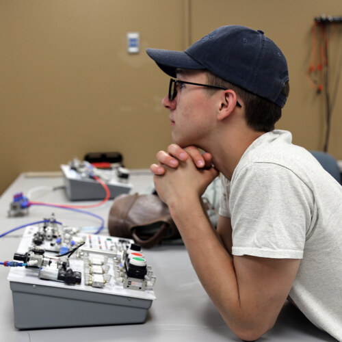 Student at an electronics and automation controls trainer